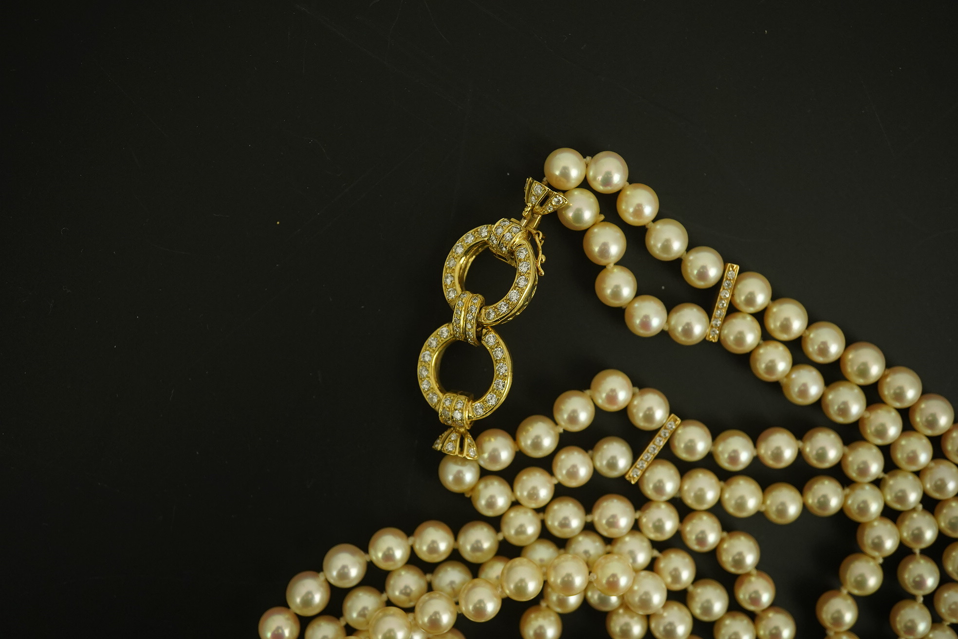 A modern double strand cultured pearl necklace, with 18k gold and diamond set twin ring clasp